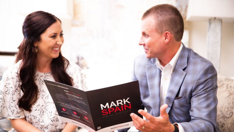 Buyers, sellers, and their respective agents are all present at a real estate closing.